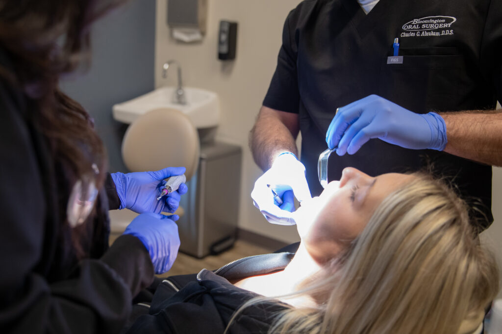 Dr Charles Abraham an oral surgeon looking at an patients mouth